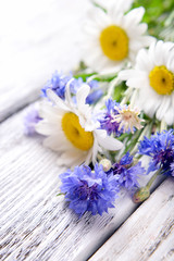 Fototapeta na wymiar Fresh wildflowers on wooden table, closeup