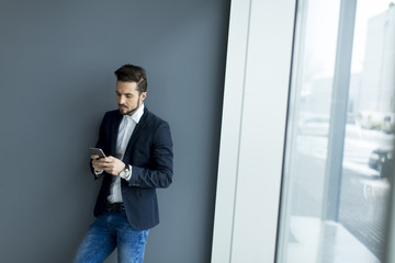 Young man with mobile phone in the office