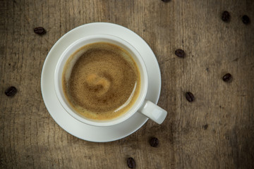 Coffee cup and beans on a wooden table