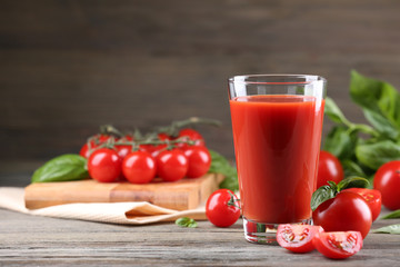 Glass of tomato juice with vegetables on wooden table close up
