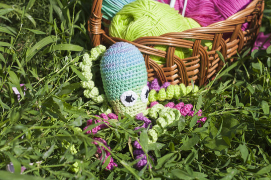 Basket with skein and knitting toy little octopus, selective focus