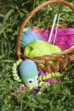Basket with skein and knitting toy little octopus, selective focus