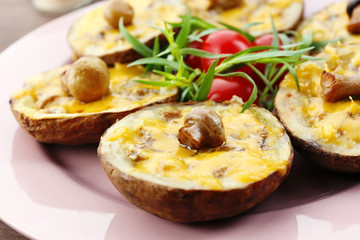 Baked potatoes with cheese and mushrooms on table close up