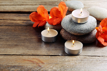 Fototapeta na wymiar Beautiful spa composition with candles and flowers on wooden table close up