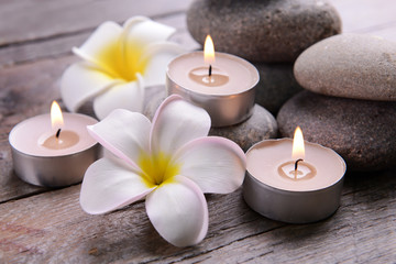 Fototapeta na wymiar Beautiful spa composition with candles and flowers on wooden table close up