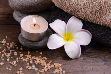 Fototapeta na wymiar Beautiful spa composition and candle with flower on wooden table close up