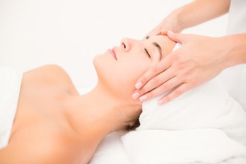 Fototapeta na wymiar Attractive woman receiving facial massage at spa center