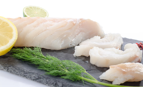 Fresh raw cod fillet on a slate plate