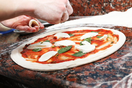 Preparing pizza on marble table, closeup