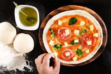 pizza and ingredients for pizza on the wooden background
