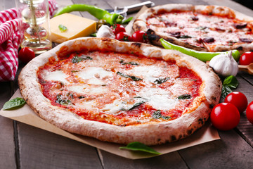 Delicious pizzas on wooden table, closeup