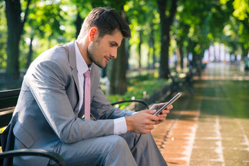 Businessman using tablet computer outdoors