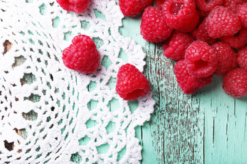 Fresh raspberries on wooden table with napkin, top view