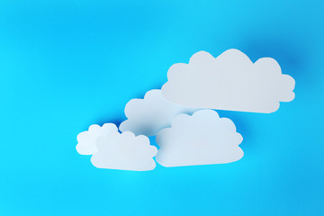 White paper clouds on blue background. Cloud computing concept.