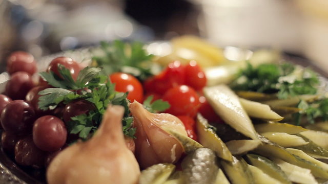 Silver dish with the pickled cucumbers, tomatoes, garlic with