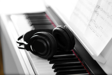 Piano with headphones and music notes close up