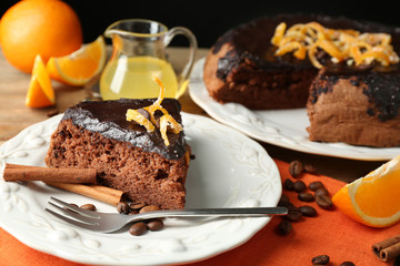 Cake with Chocolate Glaze and orange on plate, on wooden background