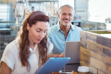 Happy man looking at camera and using laptop