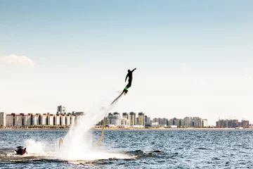 Foto auf Acrylglas Wasser Motorsport Flyboarding im Hintergrund die Stadt