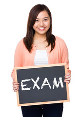 Asian woman with black board showing a word exam