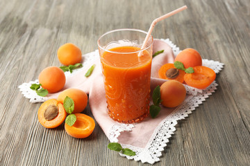 Glass of apricot juice and fresh fruits on table close up