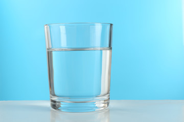 Glass of water on blue background