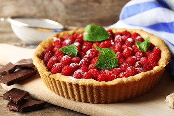 Tart with fresh raspberries, on wooden background