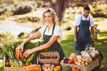 Farmer woman tidying up a table of local food