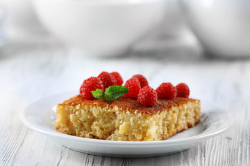 Fresh pie with raspberry in white plate on wooden table, closeup