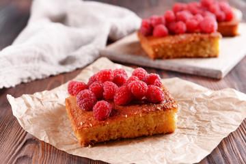 Fresh pie with raspberry on parchment on wooden table, closeup