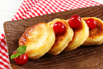 Fritters of cottage cheese with berries in plate, closeup