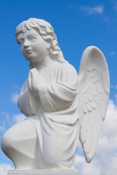Tranquil Scene of statue of  angel child at the blurred background.