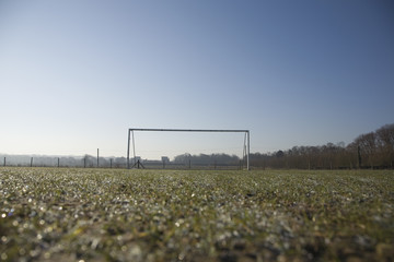 Fototapeta na wymiar empty football pitch and goal on a frosty winter morning sunrise