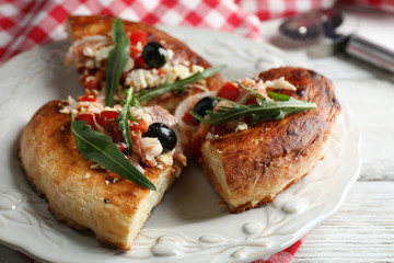 Pieces of homemade pizza on plate, on color table background