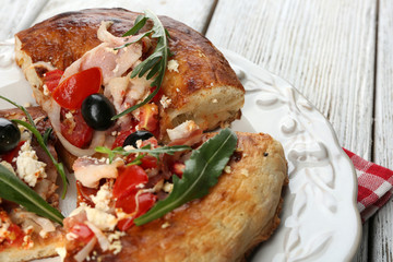 Pieces of homemade pizza on plate, on color table background