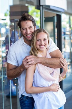 Smiling man putting arm around his girlfriend