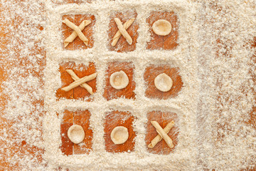 Tic tac toe with flour and fresh handmade italian pasta orecchiette and maccheroni