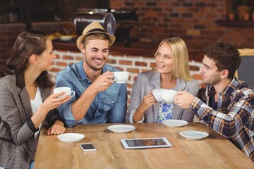 Smiling friends enjoying coffee together