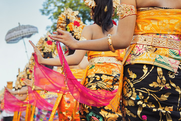 Group of beautiful Balinese girls in bright traditional costumes - sarongs decorated by hindu Barong and Garuda masks. Arts and culture of Bali island and Indonesia people and asian travel backgrounds