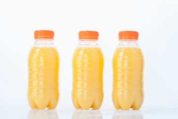 Orangensaft-Flaschen auf weißem Hintergrund, close up