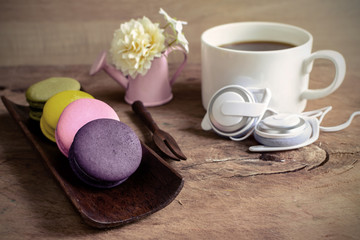 Colorful macaroons and a cup of coffee on wooden table, Vintage