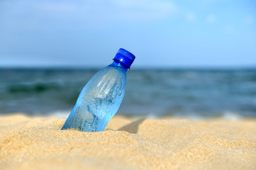 Bottle of the fresh water on sand
