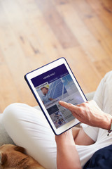 Woman Looking At News App On Digital Tablet