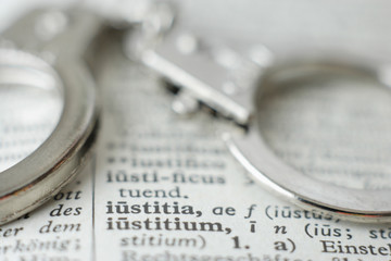 Extreme Nahaufnahme von Handschellen an W&ouml;rterbuch