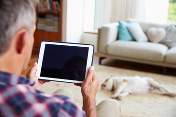 Close Up Of Man Using Digital Tablet At Home