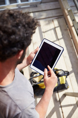 Construction Worker Using Digital Tablet On Building Site