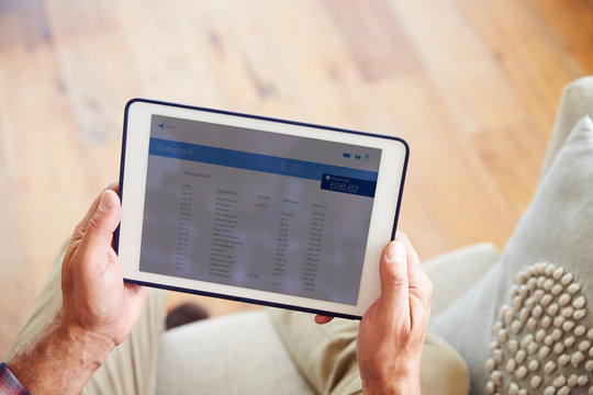 Man Looking At Banking App On Digital Tablet