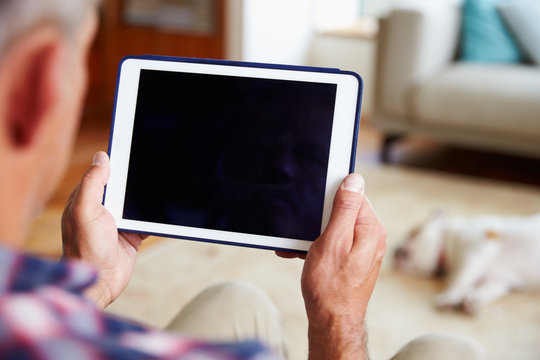 Close Up Of Man Using Digital Tablet At Home