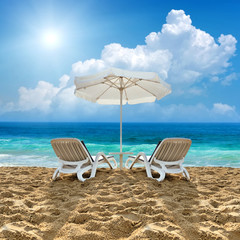 Beach chair and white umbrella on beach