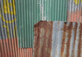 An abstract background image of rusty corrugated zinc sheets overlapping to form a fence